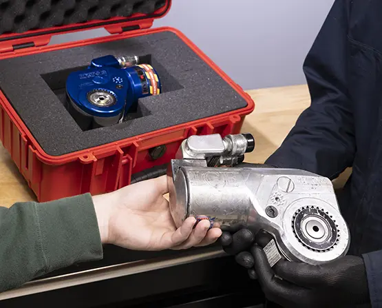 Two people exchanging an old, worn-down tool for a shiny new MXT+ Hydraulic Torque Wrench